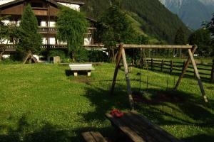 a swing in a field in front of a building at Appartement Ahrntal Maurlechen - Antratt 6 in Lutago
