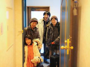 grupa ludzi stojących w drzwiach w obiekcie Hakuba Märchen House w mieście Hakuba
