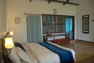 a bedroom with a large bed and a window at The Misty Mountains in Chaukori