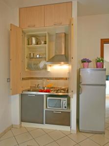 una cucina con frigorifero in acciaio inossidabile e piano cottura di Residence Mareo a Riccione