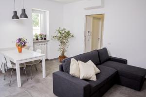 a living room with a black couch and a white table at Rosa's House Rome Airport in Fiumicino