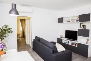 a living room with a couch and a tv at Rosa's House Rome Airport in Fiumicino