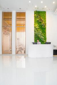 a man sitting at a desk in a room with a green wall at IW Hotel in Hong Kong