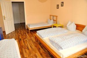 3 Betten in einem Zimmer mit Holzböden in der Unterkunft Haus Ludwig in Dresden