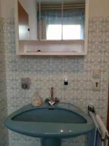 a bathroom with a blue sink and a window at Ferienwohnungen Ingrid Latschenberger in Bad Hall