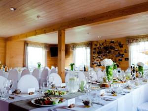 una sala da pranzo con tavoli bianchi e sedie bianche di Homestead Sartakampis a Gipenai