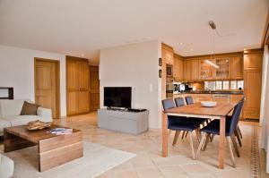 uma cozinha e sala de estar com mesa e cadeiras em Apartment Paradise - GRIWA RENT AG em Grindelwald