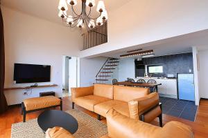 a living room with a couch and a kitchen at The Villas Ocean for Family in Seogwipo