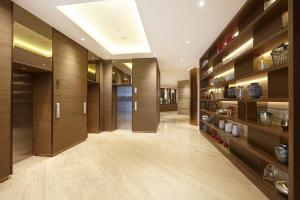 a hallway with wood paneling and a long room with shelves at Ashley Wahid Hasyim Jakarta in Jakarta