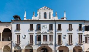 - un bâtiment blanc avec un balcon au-dessus dans l'établissement Hotel Casa Del Pellegrino, à Padoue