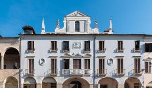 a large building with a clock on the front of it at Hotel Casa Del Pellegrino in Padova