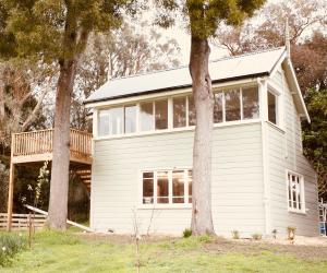 uma casa branca com árvores em frente em The Signal Box em Whanganui