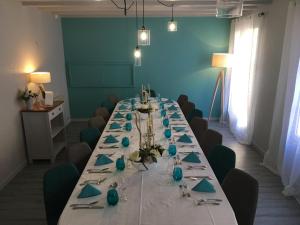 a long table in a room with blue walls at H&ocirc;tel Restaurant de la Place in Saint-Jean-dʼAng&eacute;ly