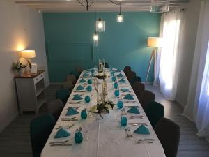 einen langen Tisch in einem Zimmer mit blauen Wänden in der Unterkunft Hôtel Restaurant de la Place in Saint-Jean-dʼAngély