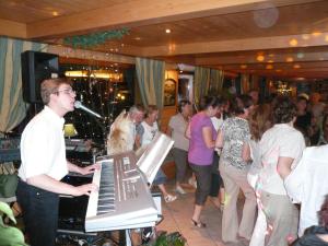 a man playing a keyboard in a crowd of people at Hôtel Restaurant "Les Sapins" Wellness & Gourmet in Manigod