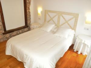 a bedroom with a large white bed and a mirror at El Castell de la Pobla de Lillet (Adults Only) in La Pobla de Lillet +57 photos