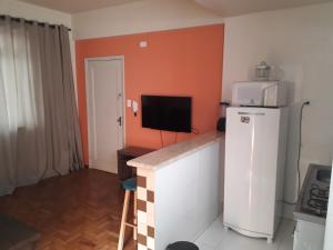 uma pequena cozinha com frigorífico e micro-ondas em Apartamento Tubal em Uberlândia
