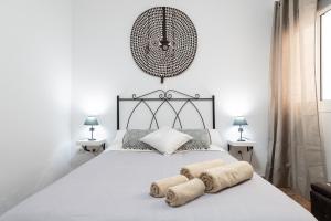 a bedroom with a large white bed with towels on it at Arinaga Luxury House Beach in Arinaga