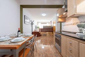 a kitchen with a table with chairs and a counter top at Arinaga Luxury House Beach in Arinaga