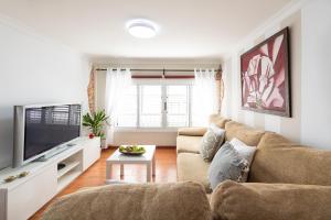 a living room with a couch and a tv at Arinaga Luxury House Beach in Arinaga +14 photos