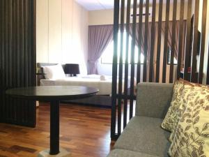 - un salon avec une table et un canapé dans l'établissement Vi Boutique Hotel, à Kuala Selangor