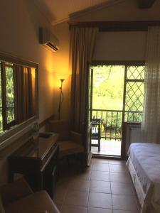 Habitación de hotel con cama y puerta corredera de cristal en Piccolo Mondo Hotel, en Agva