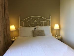 a bedroom with a large white bed with two lamps at Piccolo Mondo Hotel in Ağva