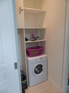 a laundry room with a washing machine with a basket on it at Le Petit Parc in Colmar