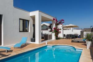 a house with a swimming pool and a patio at Villa Carmen- Lanzarote in Playa Blanca