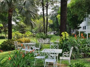 a group of tables and chairs in a park at Montien Riverside Hotel Bangkok in Bangkok