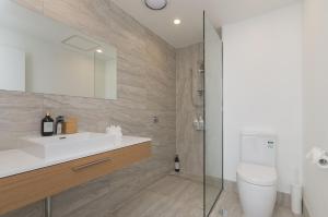 La salle de bains est pourvue d'un lavabo, de toilettes et d'une douche. dans l'établissement Sunset Place Apartments, à Perth
