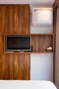 TV en una estantería de madera en una habitación en Het Kabinet, en Ámsterdam