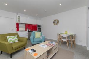 a living room with a table and chairs and a kitchen at Sunset Place Apartments in Perth