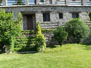 un edificio de piedra con hiedra creciendo en él en Bancal de Los Pérez, en Carataunas