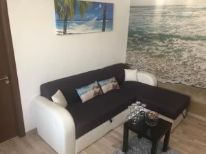 a living room with a black and white couch and a table at Apartament Antonia Sat Vacanta in Constanţa