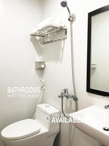 een badkamer met een toilet, een wastafel en een spiegel bij My Khe Beach Apartment Sea View in Da Nang