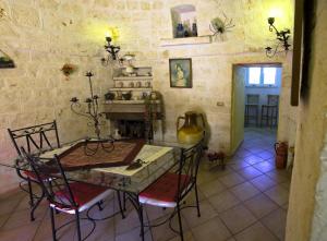 a table and chairs in a room with a stone wall at Il Trulletto in Impalata +115 photos