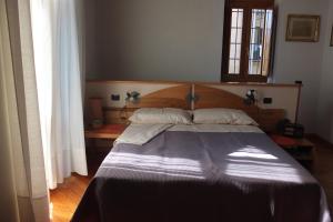 a bedroom with a large bed with a wooden headboard at I Melograni in Sora