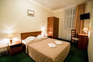 a hotel room with a bed and a desk and a chair at Dinaburg SPA Hotel in Daugavpils