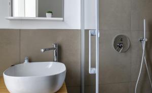 a bathroom with a white sink and a shower at Isolana Apartment in Izola