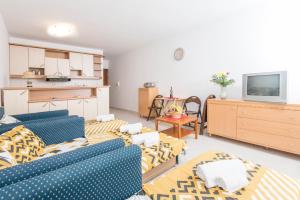 sala de estar con 2 sofás azules y cocina en Apartman Budva, en Budva