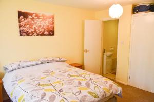 a bedroom with a bed and a painting on the wall at Little Lulworth in Bordon
