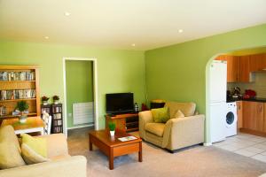 a living room with a couch and a tv at Little Lulworth in Bordon