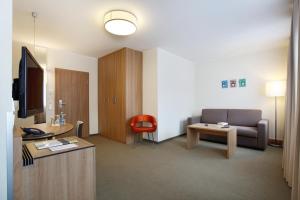 a living room with a couch and a tv in a room at Hotel am Jakobsmarkt in Nuremberg