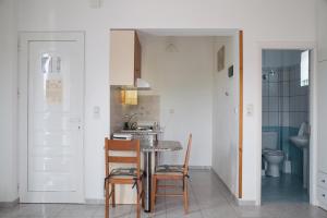 a kitchen with a table and chairs and a sink at Marmaron Rooms in Agiokampos