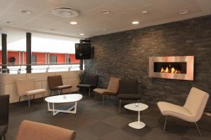 a waiting room with chairs and a fireplace at Hotel Svendborg in Svendborg