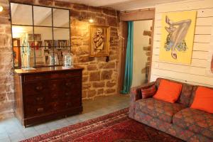 uma sala de estar com um sofá e uma parede de pedra em L'ateliere em Ottrott