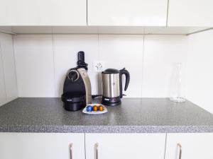 a kitchen counter with a coffee maker and a coffee pot at CITY STAY - Ringstrasse in Brüttisellen