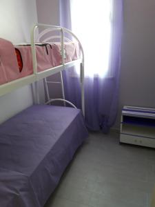 a bedroom with two bunk beds and a window at Appartamento "Le Vele" in Castellammare del Golfo