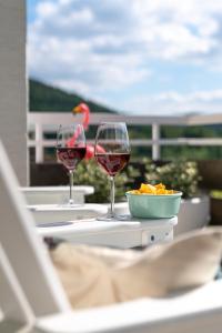 two glasses of wine and a bowl of food on a table at Queens Castle in Winterberg